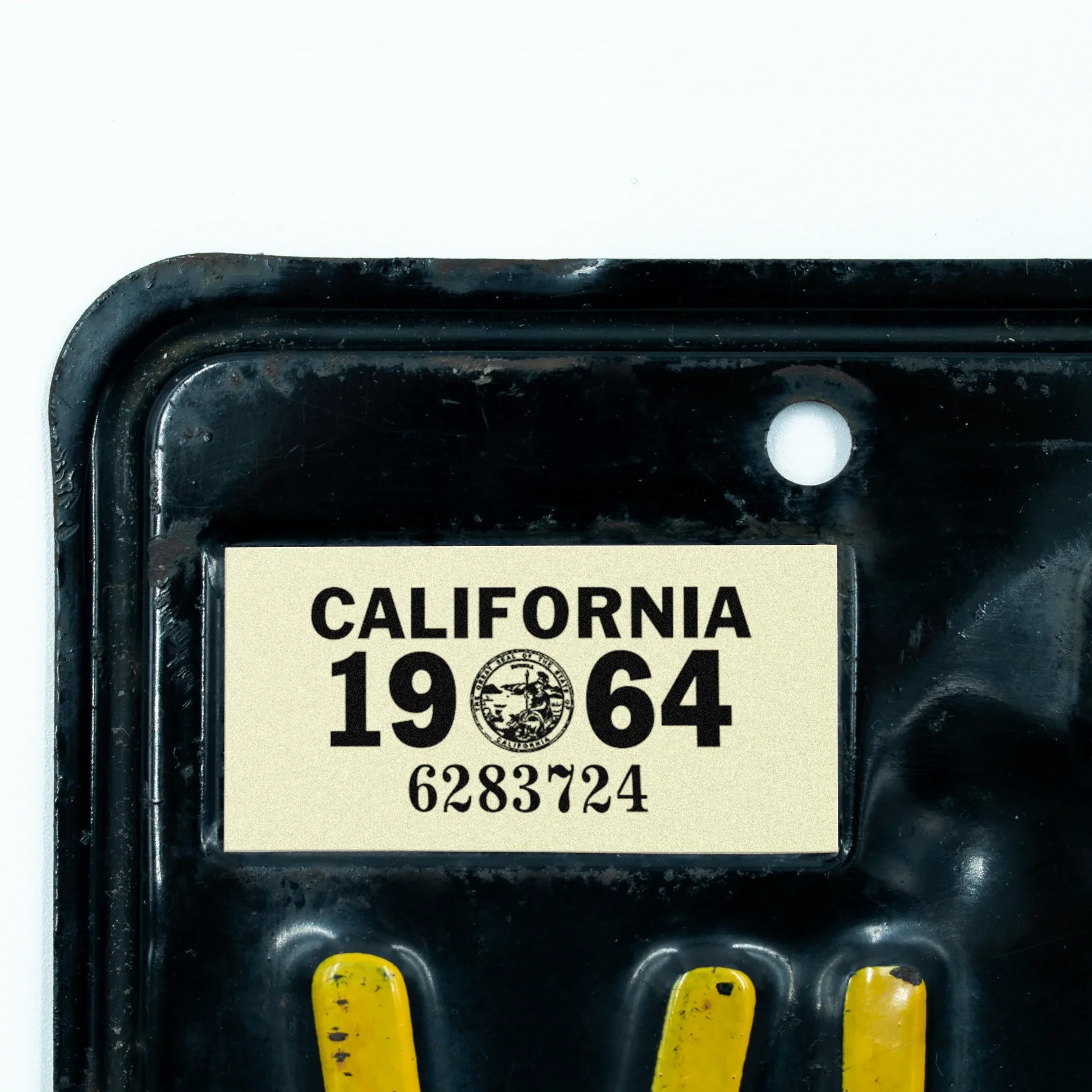 California license plate 1964 year sticker applied to upper corner of black California plate — YOM Series