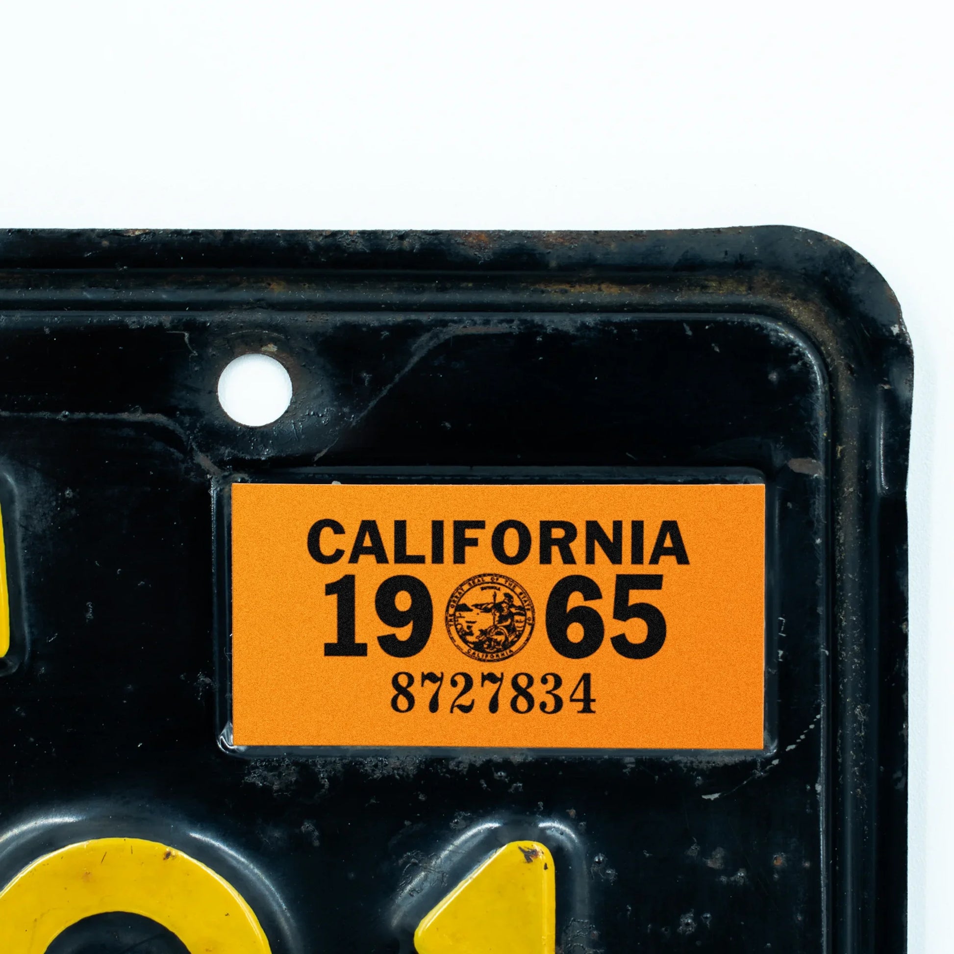 California license plate 1965 year sticker applied to upper corner of black California plate — YOM Series