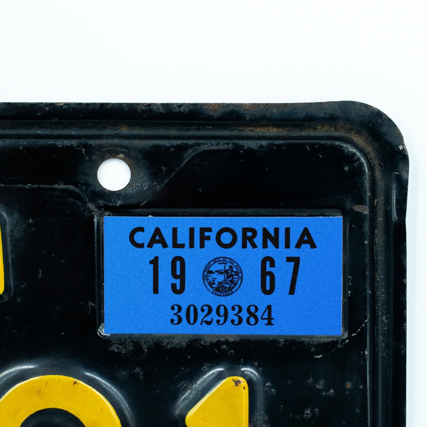 California license plate 1967 year sticker applied to upper corner of black California plate — YOM Series