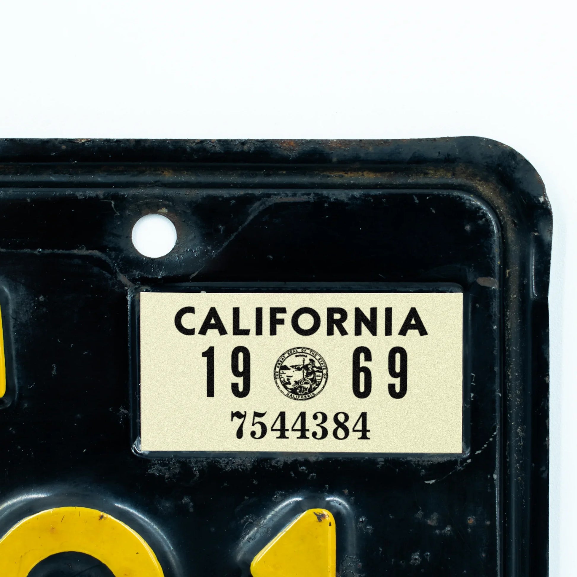 California license plate 1969 year sticker applied to upper corner of black California plate — YOM Series