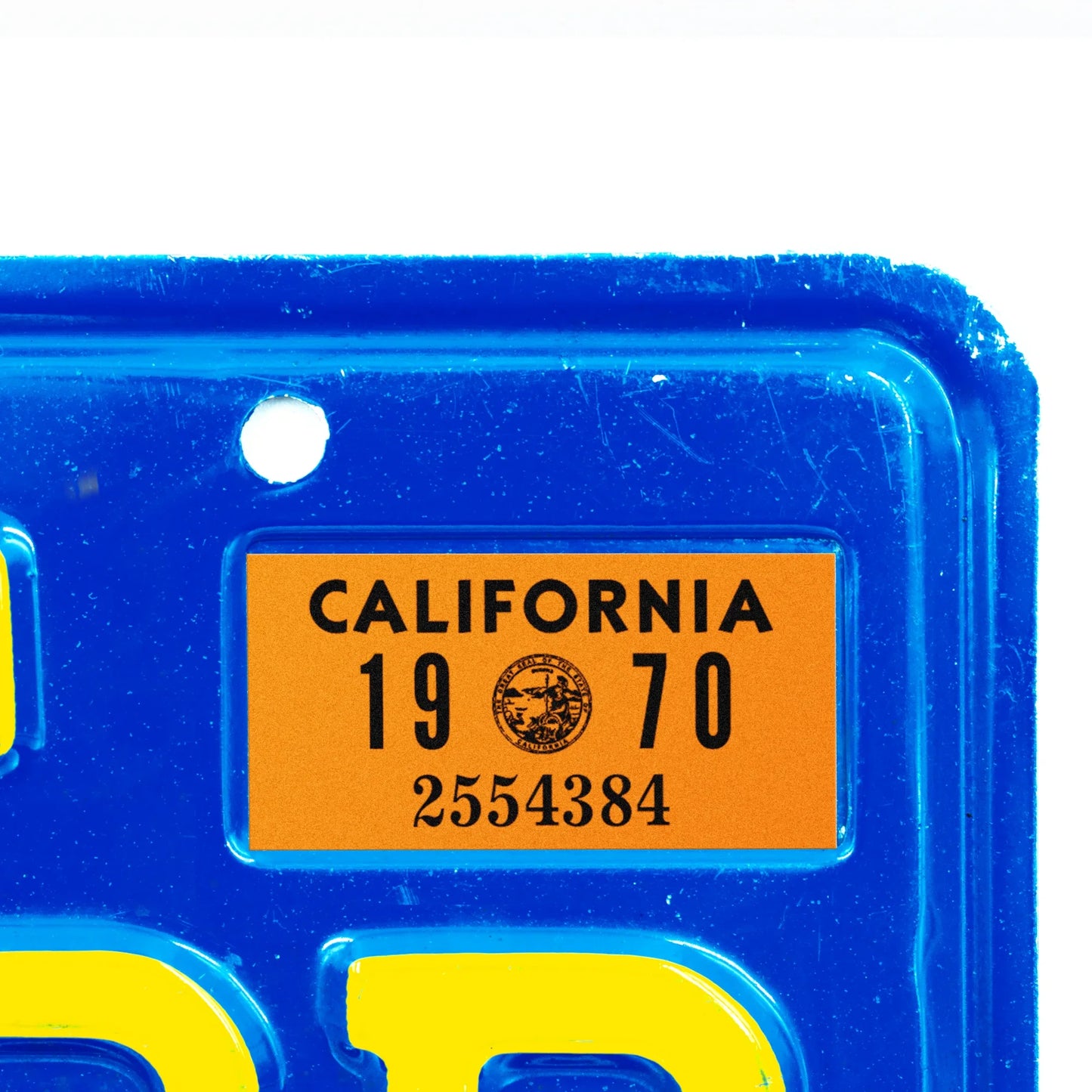 California license plate 1970 year sticker applied to upper corner of blue California plate — YOM Series