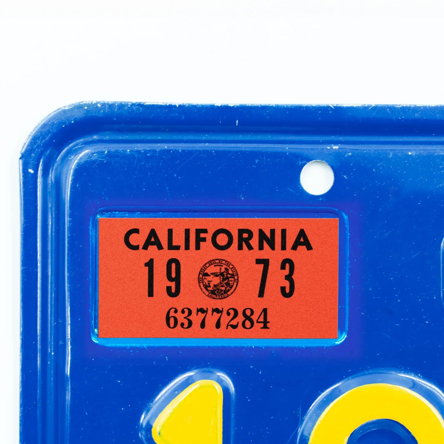 California license plate 1973 year sticker applied to upper corner of blue California plate — YOM Series