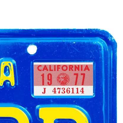 California license plate 1977 year sticker applied to upper corner of blue California plate — YOM Series