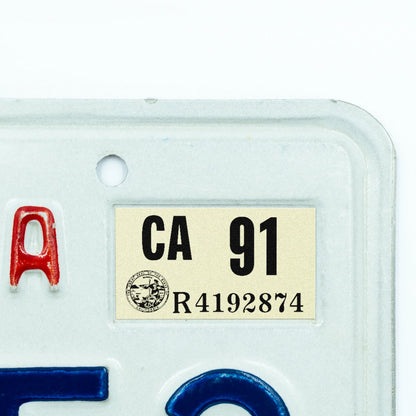 California license plate 1991 year sticker applied to upper corner of white California plate — Classic Series