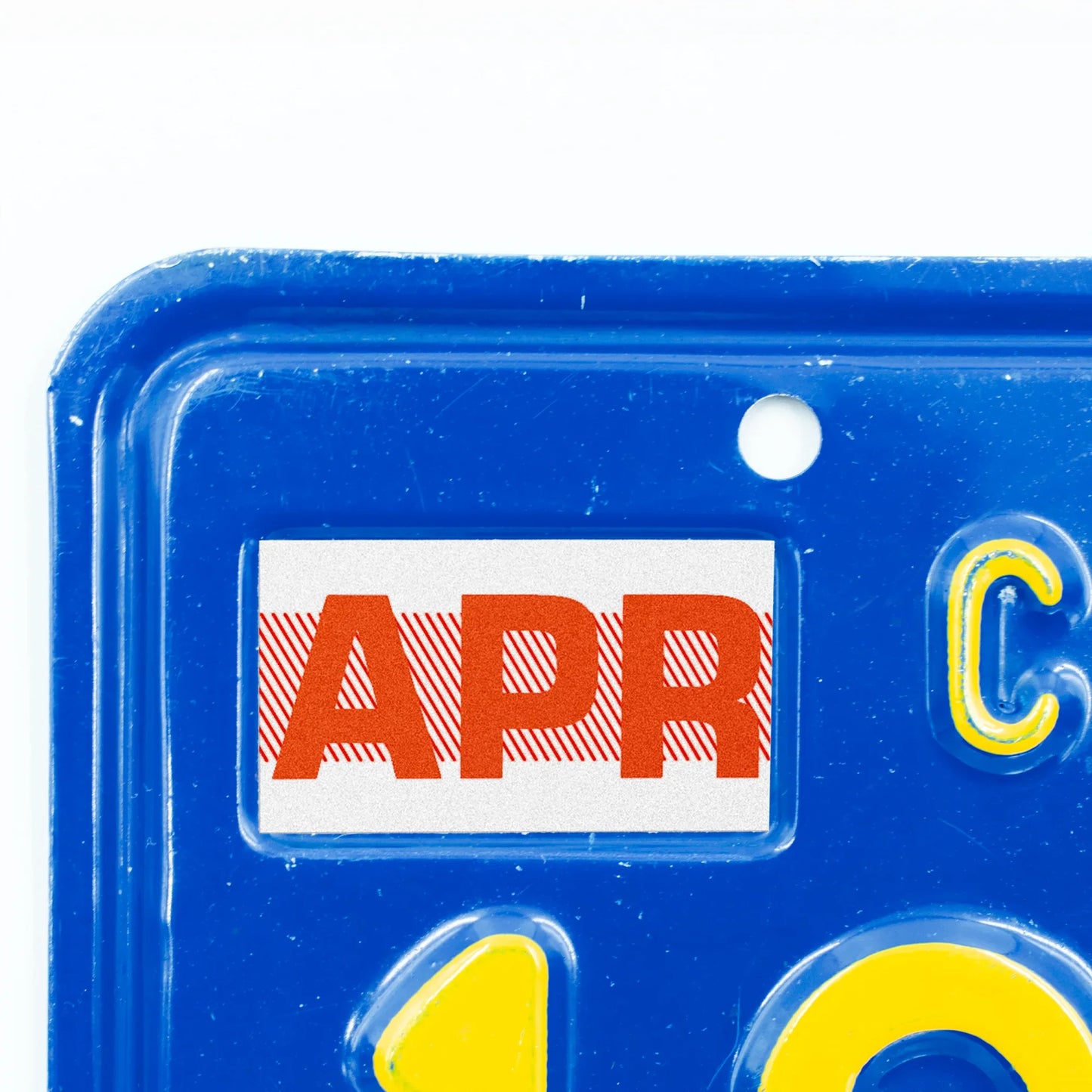 California license plate April month sticker applied to upper corner of blue California plate — Red Series