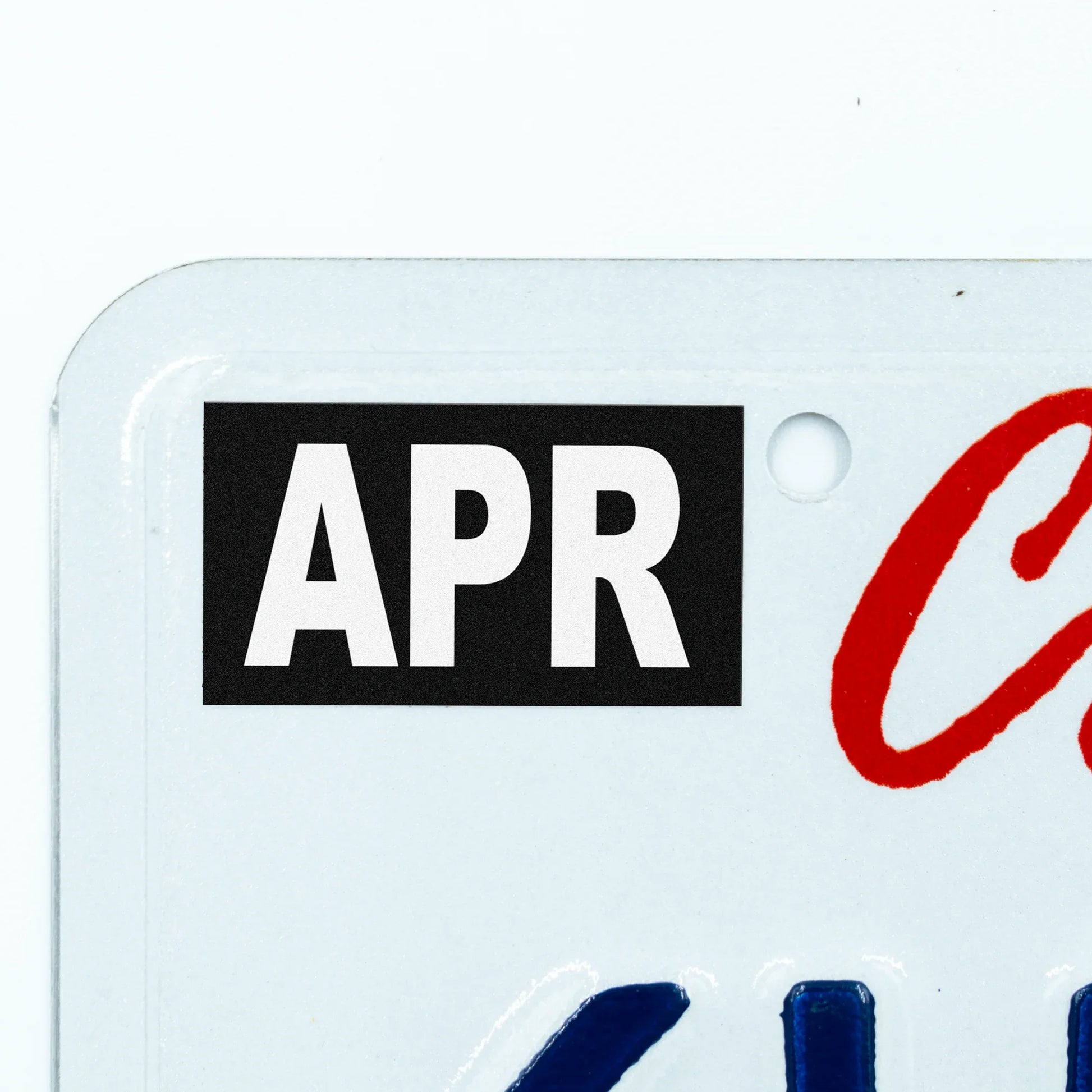 California license plate April month sticker applied to upper corner of white California plate — Stealth Series