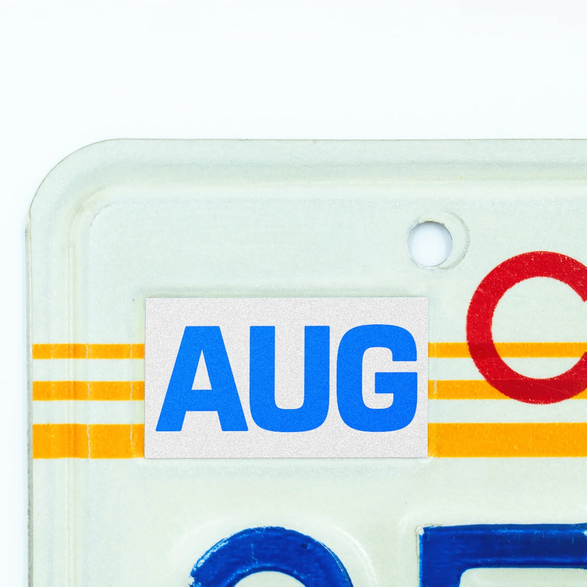 California license plate August month sticker applied to upper corner of 1980s sunset California plate — Blue Series