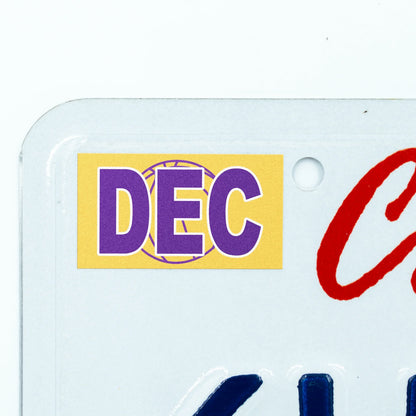 California license plate December month sticker applied to upper corner of white California plate — Courtside Series