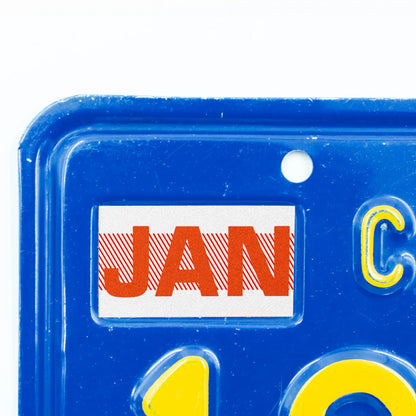 California license plate January month sticker applied to upper corner of blue California plate — Red Series