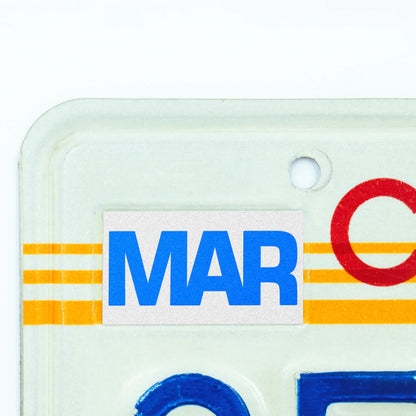 California license plate March month sticker applied to upper corner of 1980s sunset California plate — Blue Series