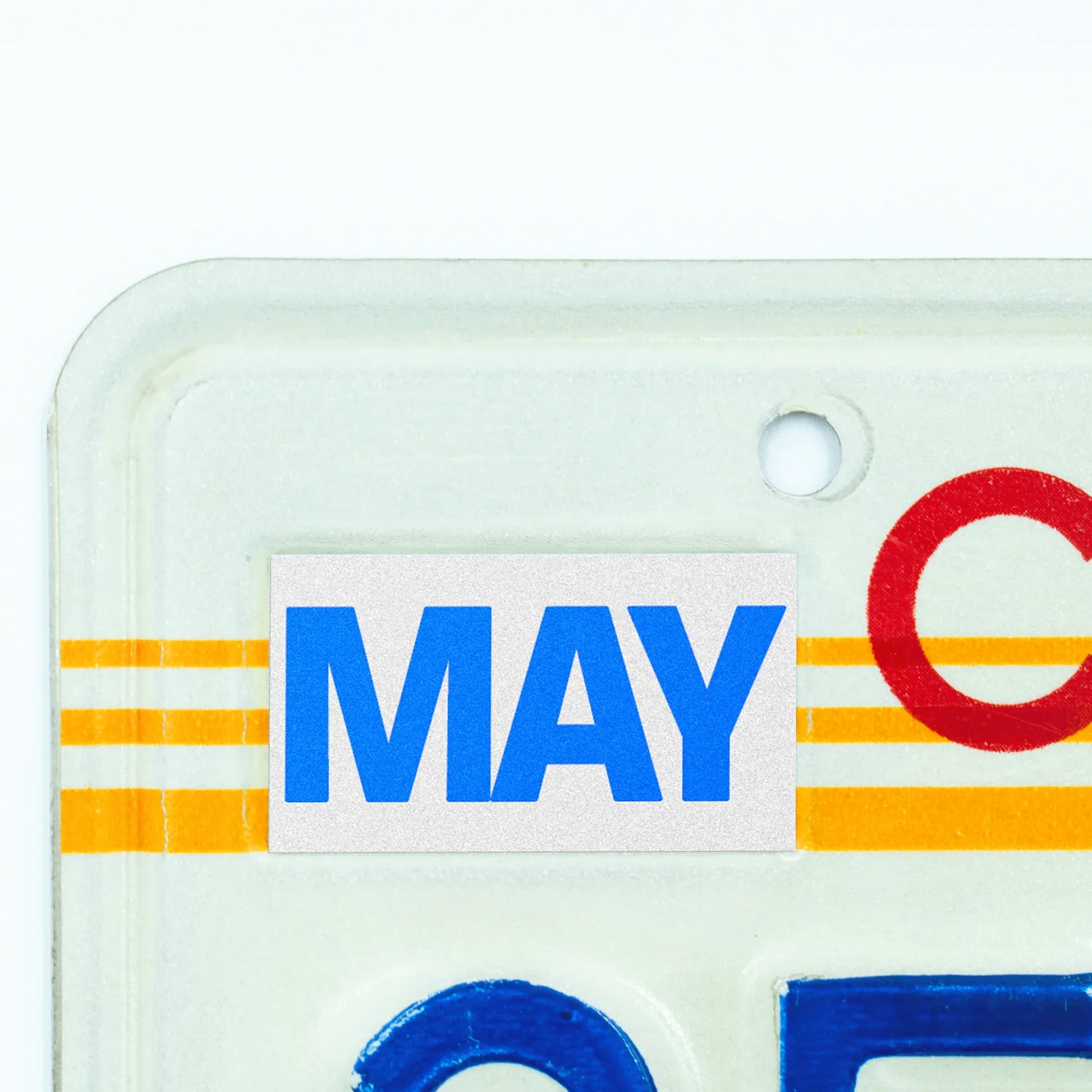 California license plate May month sticker applied to upper corner of 1980s sunset California plate — Blue Series