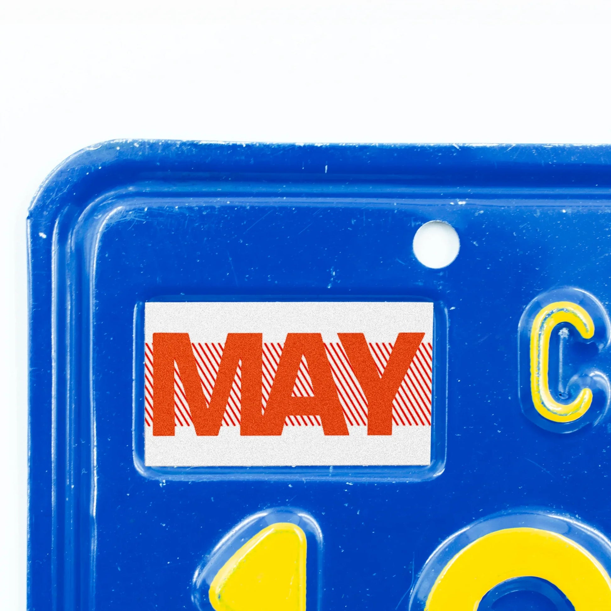 California license plate May month sticker applied to upper corner of blue California plate — Red Series