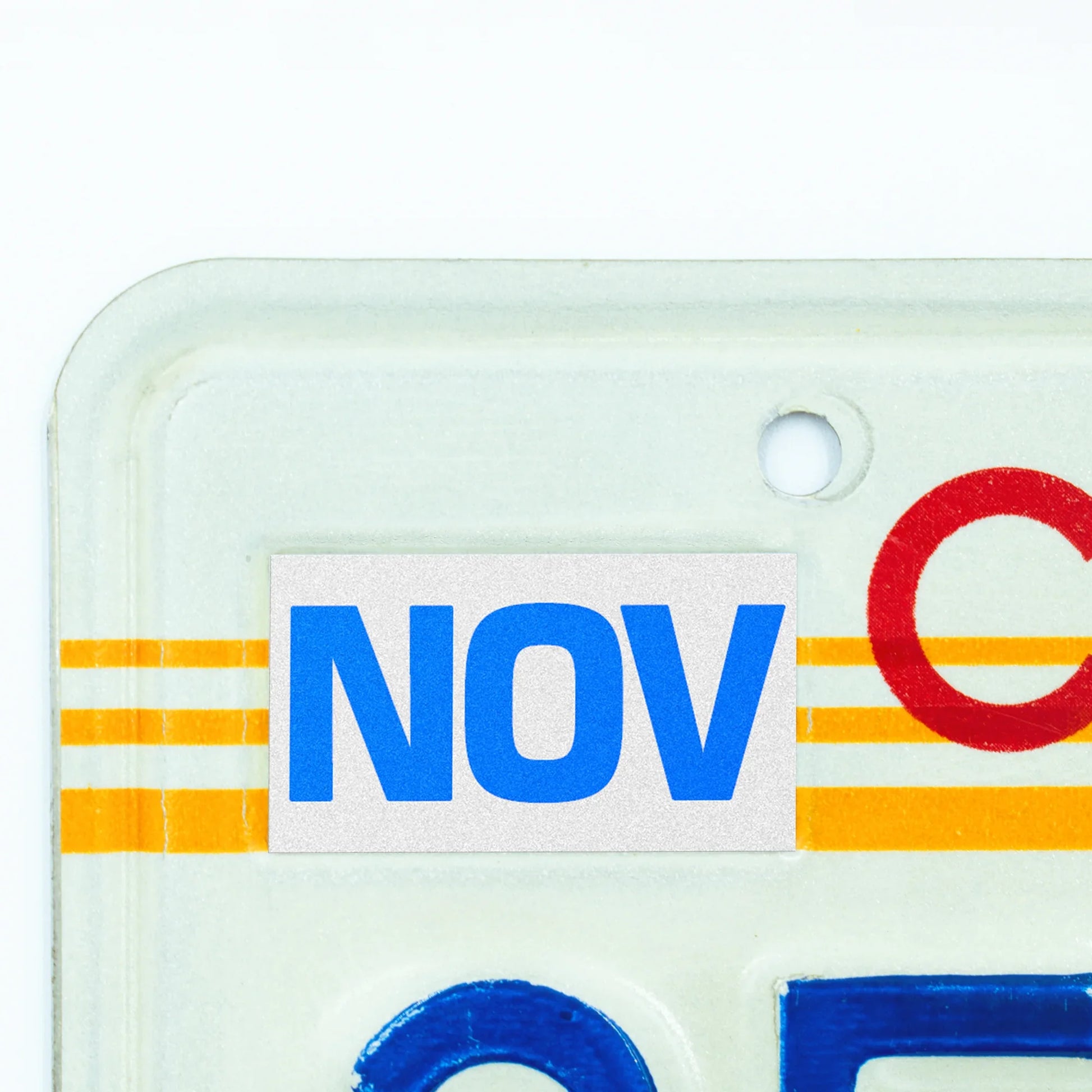 California license plate November month sticker applied to upper corner of 1980s sunset California plate — Blue Series