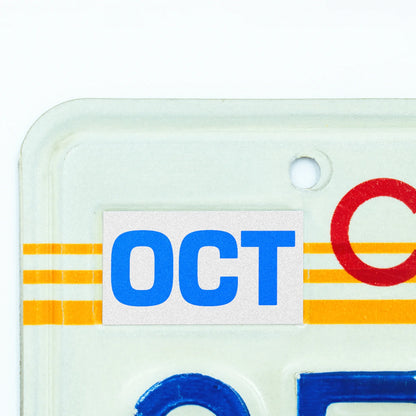 California license plate October month sticker applied to upper corner of 1980s sunset California plate — Blue Series