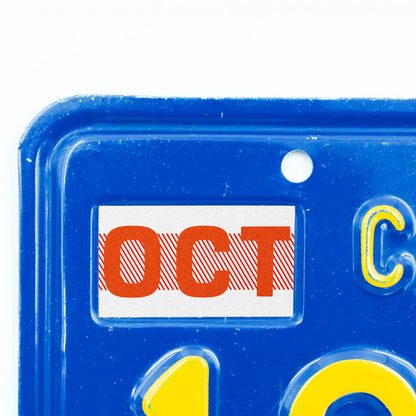 California license plate October month sticker applied to upper corner of blue California plate — Red Series