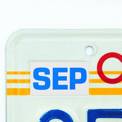 California license plate September month sticker applied to upper corner of 1980s sunset California plate — Blue Series