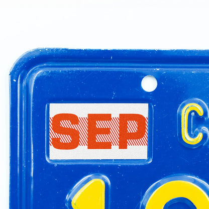 California license plate September month sticker applied to upper corner of blue California plate — Red Series